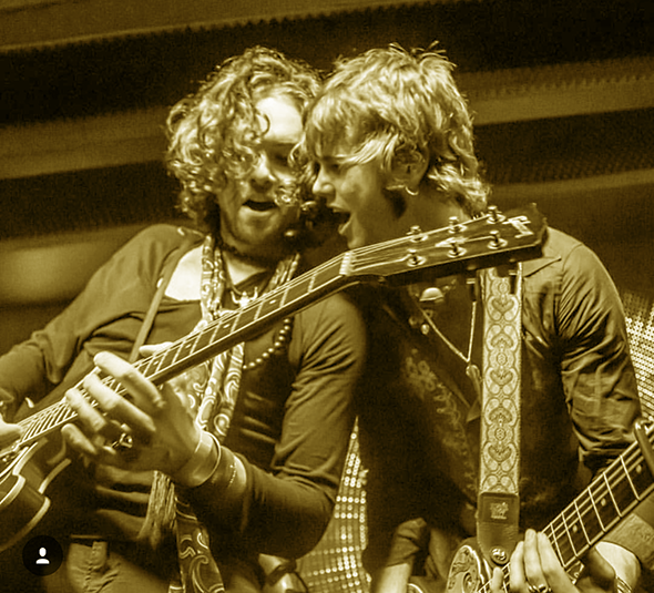 Two musicians performing with acoustic guitar